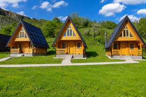 three wooden houses with solar panels on a green field at BB CHALET in Kolašin +80 photos
