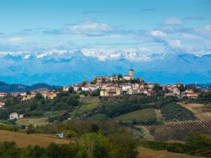 a town on a hill with mountains in the background at Tiny House nel cuore del Monferrato in Conzano