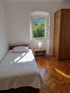 a bedroom with a bed and a window at Macmalić in Zbičina