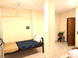 a bedroom with a bed and a room with a plant at Villa Stay in Pondicherry