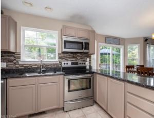 a kitchen with a stove and a microwave at The Universal Home Stay in Akron