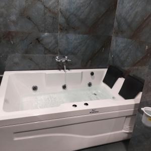 a white bath tub in a bathroom at Hotel Raddizone in Gandhinagar