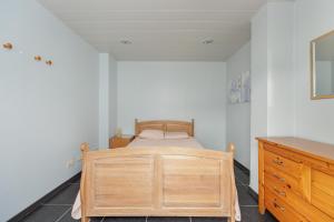 a bedroom with a wooden bed and a dresser at jutta in Mechelen +28 photos