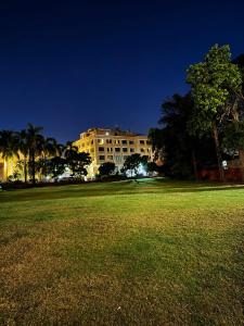 ein großes Gebäude bei Nacht mit einem Grasfeld in der Unterkunft Red Queen in Raigarh