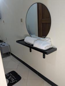 a mirror on a shelf in a bathroom with towels at Masaka BnB in Masaka