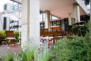 a garden with wooden chairs and flowers in front of a building at Bawelsberger Hof in Dillingen an der Saar