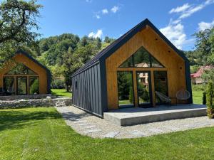 a house with a black roof and large windows at Flore's Garden in Bran
