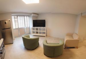 a living room with two chairs and a flat screen tv at La Casa del Principe in Alì