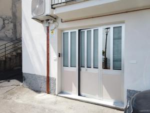 a white garage door on a building with a fan at La Casa del Principe in Alì