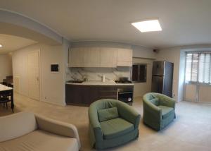 a living room with two chairs and a kitchen at La Casa del Principe in Alì