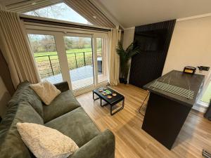 a living room with a couch and a table at Rosetta Retreats in Peebles +1 photo