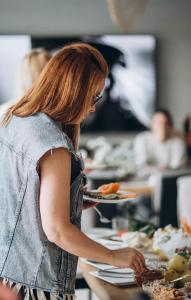 a woman standing at a counter preparing food at Клубний дім D2 in Chornomorsk
