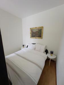 a bedroom with a large white bed and a table at Apartament Maja 10-3 in Nowy Sącz