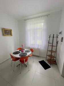 a dining room with a table and red chairs at Apartament Maja 10-3 in Nowy Sącz