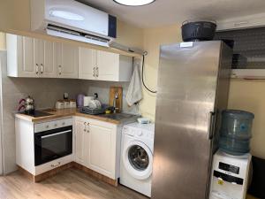 a kitchen with a refrigerator and a washing machine at Villa ADUSHI Nashec in Prizren
