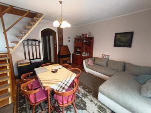 a living room with a table and chairs and a couch at Alina vendégház in Mezőkövesd
