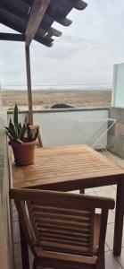 a wooden table with a potted plant on a beach at The Loft'y #3 in Famara