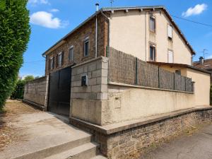 a building with a fence on the side of it at Résidence d'Emilie in Luxeuil-les-Bains