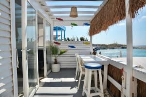 a porch with a table and chairs and the ocean at Seaside Beach Chalet in Anfeh PEARL in Anfah