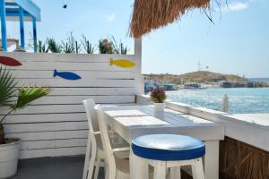 a white table and chairs on a patio with the water at Seaside Beach Chalet in Anfeh PEARL in Anfah +6 photos
