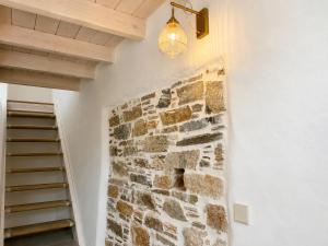 a stone wall with a light fixture and a staircase at Palokastro House Quiet Village Stay with Terrace in Samos +1 photo