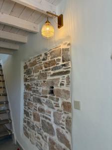 a room with a stone wall with a light on it at Palokastro House Quiet Village Stay with Terrace in Samos