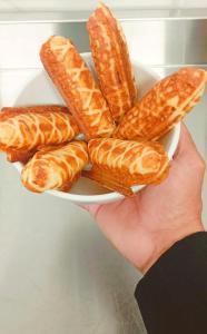 a person holding a plate of breadsticks at Flat Pedra Branca Hotel in Palhoça