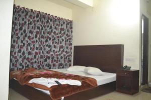 ein Schlafzimmer mit einem Bett und einem Vorhang mit Blumenmuster in der Unterkunft Dynamic SH Resort in Cox's Bazar