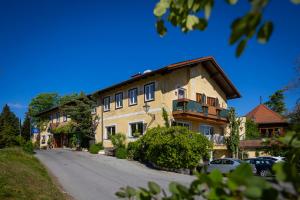 a large building on a street with cars parked in front at Hotel Restaurant - Häuserl im Wald Graz in Graz