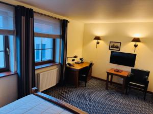 a hotel room with a desk and a bed and a computer at Hotel Tumski in Płock