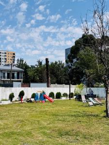 a park with a red slide in the grass at Kakhaberi Cottages in Stantsiya Batumi-Passazhirskaya