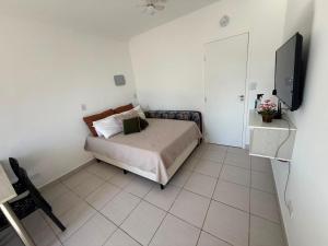 a bedroom with a bed and a flat screen tv at Studio 1202 Confortável, Piscina e próximo a praia! in Guarujá +21 photos