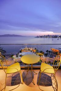 a table and chairs on a balcony with a view of the ocean at Hotel Saranda Butrinti, Affiliated by Meliá in Sarandë