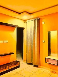 a living room with orange walls and a mirror at hotel shivalik palace in Dhanbād