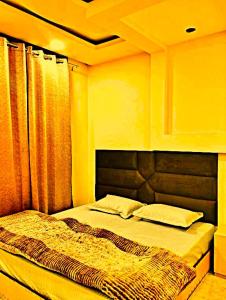 a bedroom with a bed with a headboard and curtains at hotel shivalik palace in Dhanbād