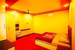 a room with a bed in a room with yellow walls at hotel shivalik palace in Dhanbād