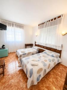 a bedroom with two beds and a television at Soutullo Praia in Sanxenxo