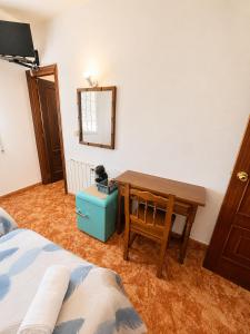 a bedroom with a desk and a table and a mirror at Soutullo Praia in Sanxenxo