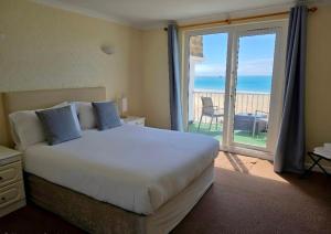 a bedroom with a bed and a view of the ocean at Beau Rivage in St. Brelade