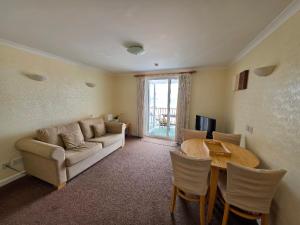 a living room with a couch and a table at Beau Rivage in St. Brelade
