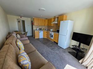a living room with a couch and a kitchen at Beau Rivage in St. Brelade