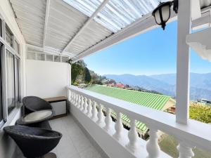 a balcony with two chairs and a view at Hotel White Yak Darjeeling in Darjeeling