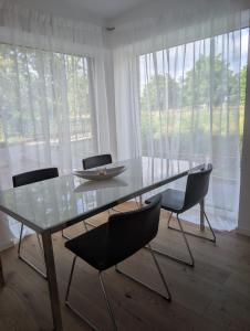 a glass table and chairs in a room with windows at Komfortables 2-Zimmer Apartment in Rinteln in Rinteln
