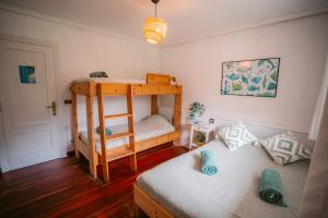 ein kleines Zimmer mit einem Etagenbett und einer Couch in der Unterkunft SURFbase Loredo in Loredo + 73 Fotos