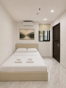 a white bedroom with a large bed in it at Dreamora Corner Hotel in Hanoi