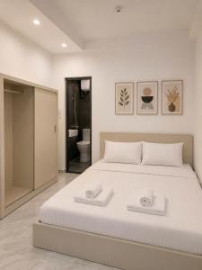a bedroom with a large white bed with two towels at Dreamora Corner Hotel in Hanoi