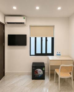 a room with a desk and a tv and a chair at Dreamora Corner Hotel in Hanoi