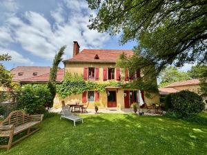 a house with a yard with benches in front of it at Les Temps Des Sources in Veyrines-de-Domme