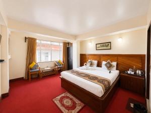 a hotel room with a large bed and a window at Hotel White Yak Darjeeling in Darjeeling