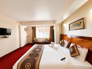 a hotel room with a large bed and a tv at Hotel White Yak Darjeeling in Darjeeling